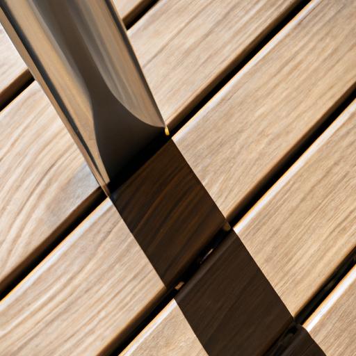 Gần cận một chân bàn gỗ với khung inox được đặt ở nơi tránh ánh nắng trực tiếp.